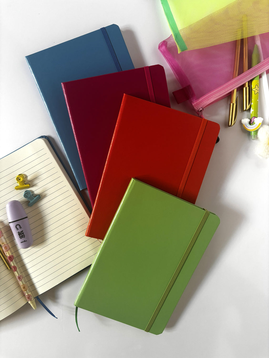 Taccuini classici formato A5 con copertina rigida ed elastico in vari colori tra cui verde mela, fucsia, arancio e azzurro versione righe