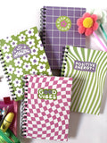 Set di quattro quaderni d'autore A5 a spirale collezione Good Vibes con copertine colorate a motivi geometrici e scritte motivazionali su sfondo bianco.