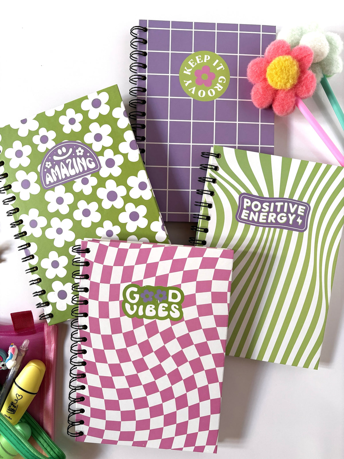 Set di quattro quaderni d'autore A5 a spirale collezione Good Vibes con copertine colorate a motivi geometrici e scritte motivazionali su sfondo bianco.