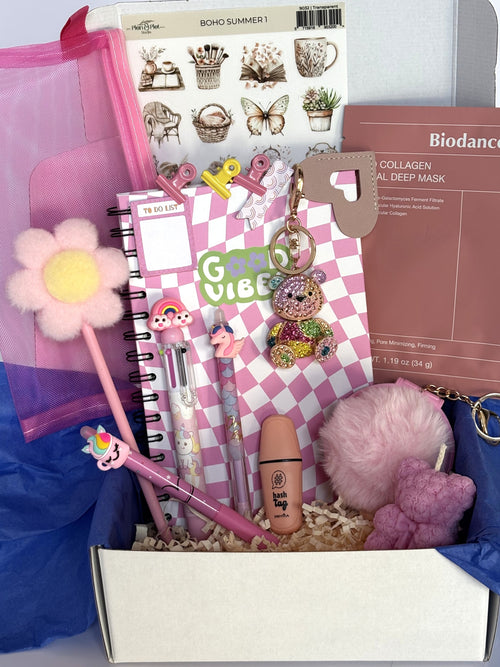 Cofanetto regalo Positive Energy C.Moon da 64.90€ in variante rosa confetto, con quaderno a scacchi Good Vibes, candela a orsetto rosa, maschera Biodance rosa, portachiavi specchietto rosa con pompon e portachiavi gioiello a forma di orsetto di strass multicolor.